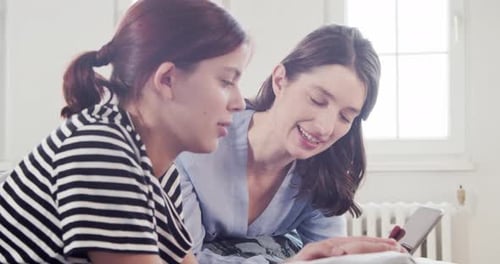 Young Adults Using Mobile Device Together Indoors