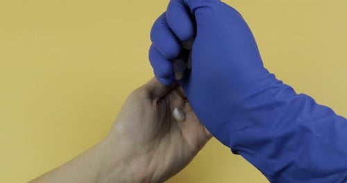 Hand in Blue Medical Handschuh bringt eine große Menge weißer Pille in die Hand einer Frau