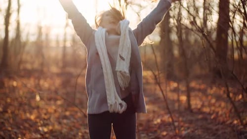 Positive Happy Woman Throwing Leaves in Autumn in Park