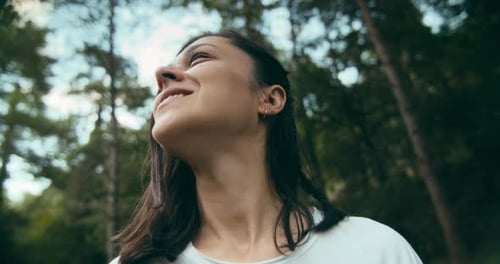 Porträt einer jungen erwachsenen Frau, die im Urlaub die Reise in den Wald genießt