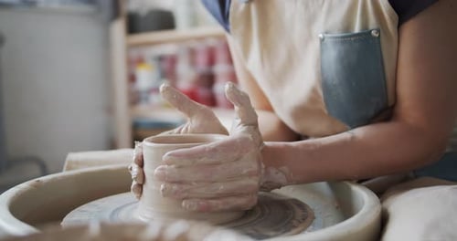 Potter's Hands Shaping Clay on a Wheel
