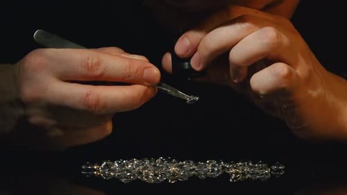 Hands Inspecting Faceted Gems With Magnifying Glass