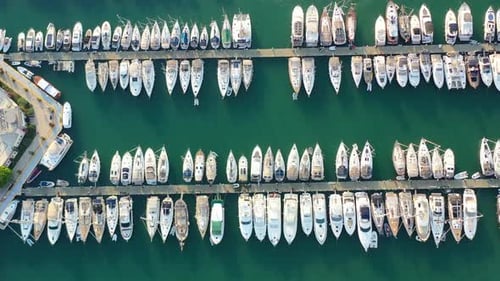 Luftaufnahme von oben nach unten auf Segelboote, die im Yachthafen von Bodrum mit türkisgrünem Wasser im Sommer angedockt sind