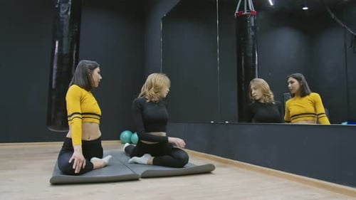 Two Women Doing Yoga Exercises in Studio