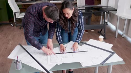Architects Collaborate on Blueprints in Modern Office