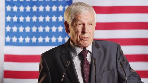 Man Giving Political Speech with American Flag Backdrop