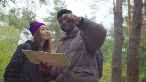 Couple Exploring Forest with Map on Hiking Adventure
