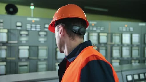 Engineer Operating Control Panel in Industrial Setting