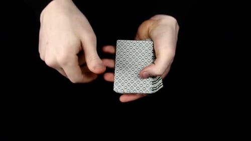 Cartes à jouer étalées, changer de carte, sur une surface noire par un magicien