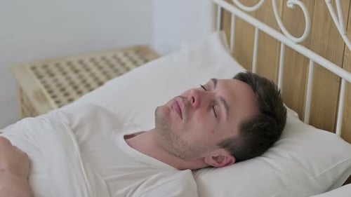 Young Adult Man Sleeping Peacefully in Bed