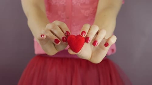 Woman Holding a Red Heart Decoration Close Up