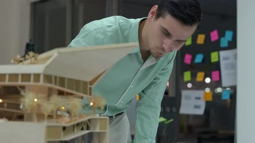 Man Examining Architectural Model in Office Workplace