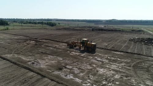 Luftaufnahme des Feldes und massive maschinelle Nivellierung des Bodens für den Bau