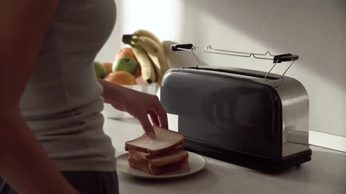 Woman Making Toast for Breakfast in Kitchen
