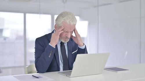 Stressed Businessman Working on Laptop in Office
