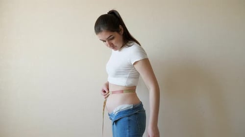 Plump Woman Makes Measurements of the Waist with a Centimeter Tape