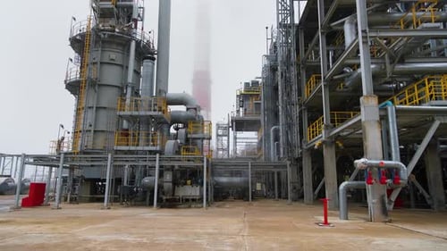 Site of oil refinery. Steel structures in foreground. Chimney in background.