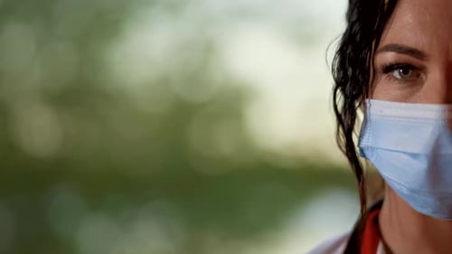 Close Face View with Copy Space of Young Female Doctor or Nurse Wearing Surgical Mask and Looking at