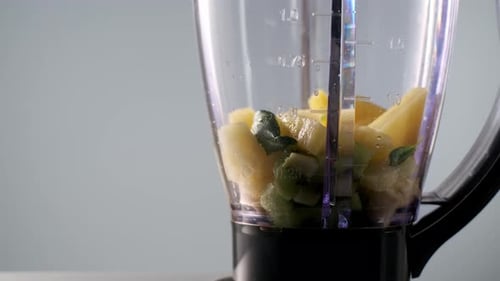 Spinat in den Mixer geben, um veganen Smoothie zuzubereiten