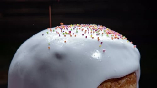 Rotierende Oster-Kuchendekoration mit weißer Glasur und bunter Zuckerstreusel Traditionelle Bäckerei