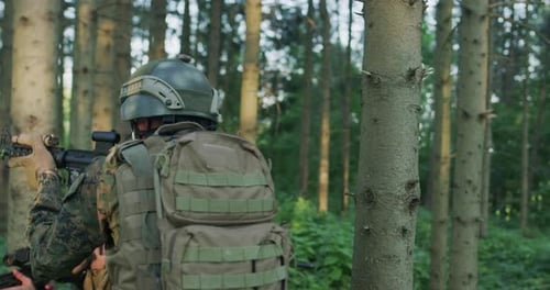 Soldats entièrement équipés portant un uniforme de camouflage attaquant l'ennemi