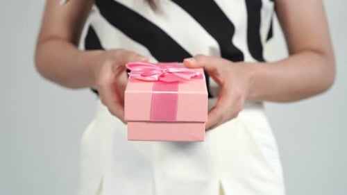 Woman Holding a Pink Gift Box with Ribbon