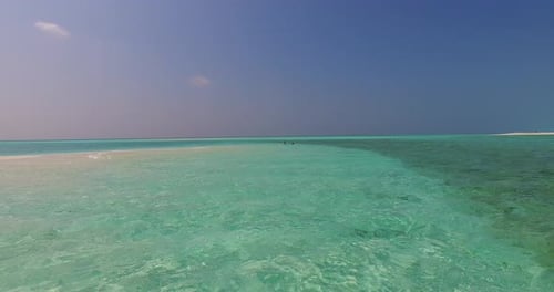 Wide angle flying tourism shot of a paradise sunny white sand beach and turquoise sea background in