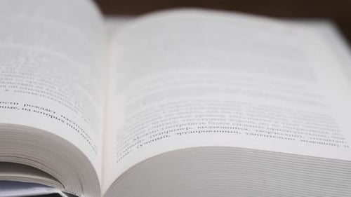 Hand Turning Pages of an Open Book