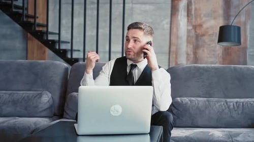 A Professional Sits in a Beautiful Dark Office in Front of a Laptop