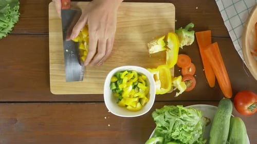 Chefin zubereitet Salat, gesundes Essen und hackt Paprika auf einem Schneidebrett in der Küche.