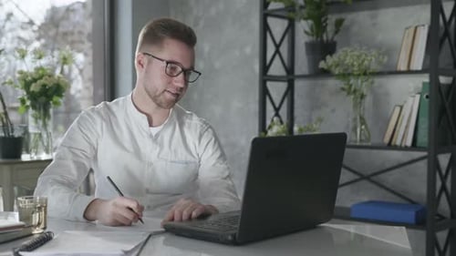 Un jeune entrepreneur travaillant sur un ordinateur fait des affaires en ligne heureux du travail effectué