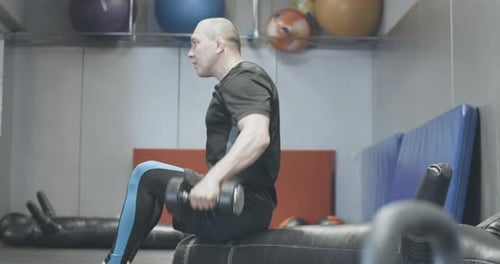 Side View of Confident Man Lifting Hand Weights in Gym. Serious Handsome Caucasian Sportsman
