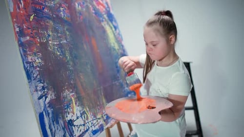 Girl Holding Paint Brush and Palette in Studio