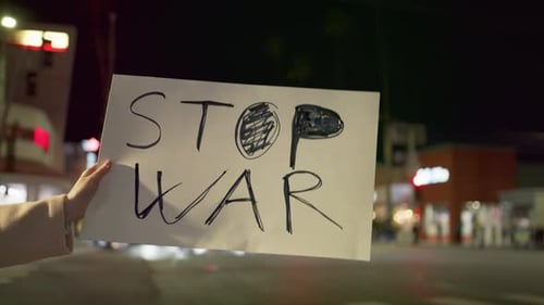 Nahaufnahme von Aktivistinnen im Freien in Zeitlupe mit STOP the WAR-Poster