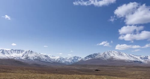 Timelapse of Sun Movement on Crystal Clear Sky with Clouds Over Snow Mountain Top