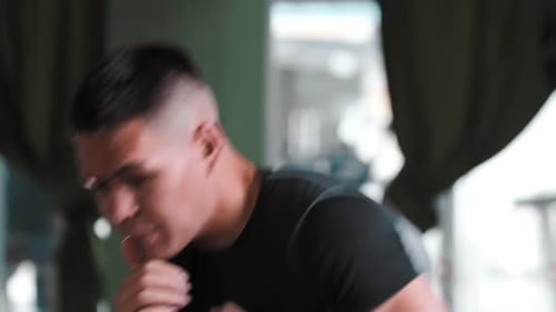 Young Man Boxing and Training in Gym