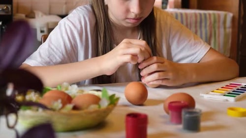 Child Girl Having Fun During Painting Eggs for Easter in Spring Time at Home