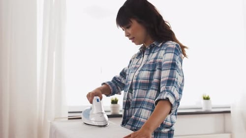 Woman Ironing Clothes at Home, Daytime
