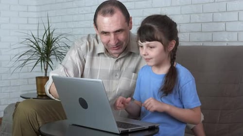 Adult and Child Using Laptop Together