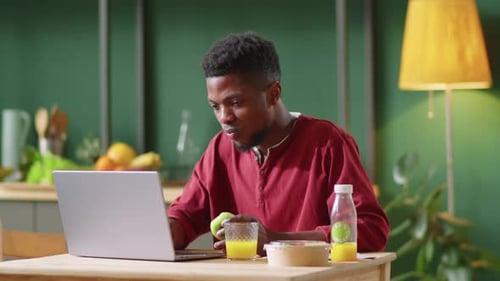 Young Adult Works While Eating Healthy Lunch