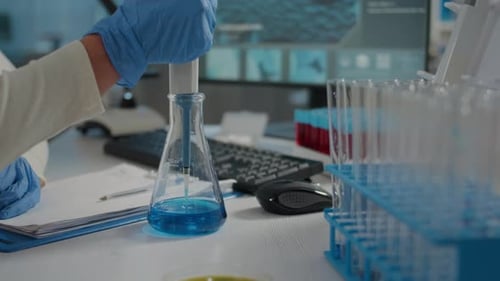 Scientist Uses Pipette in Lab Experiment