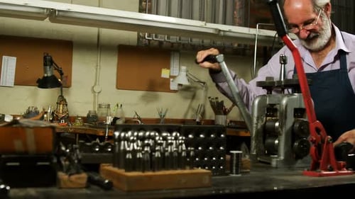 Goldsmith working on machine in workshop