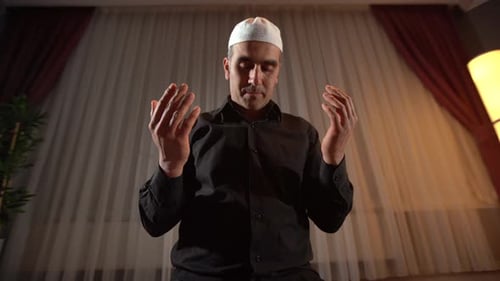Man with Cap Prays Indoors