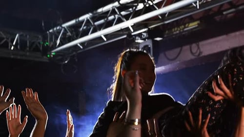 Smiling Woman Crowd Surfing at a Concert