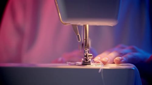 Sewing Machine Sewing Fabric with Pink and Blue Lighting
