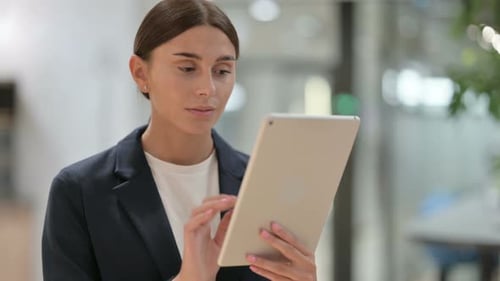 Young Woman Using Tablet in Modern Workplace