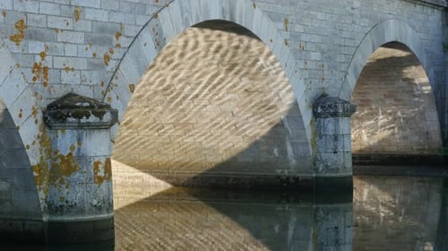 Reflejo de un antiguo puente de piedra en la superficie del río, 4K, 2160p, 30 fps, imágenes UltraHD: sol y brillo