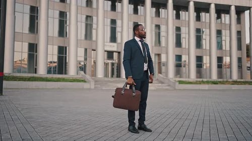 Suited Professional Stands Confidently Near Modern Building