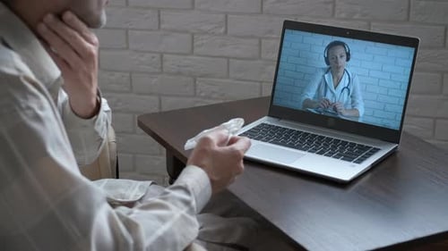 Man Having Telehealth Consultation with Doctor at Home