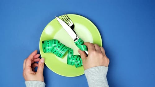 Dieting Concept: Silverware Wrapped with Measuring Tape
